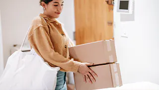 Woman carrying stacked boxes