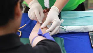 Gloved doctor administering a shot
